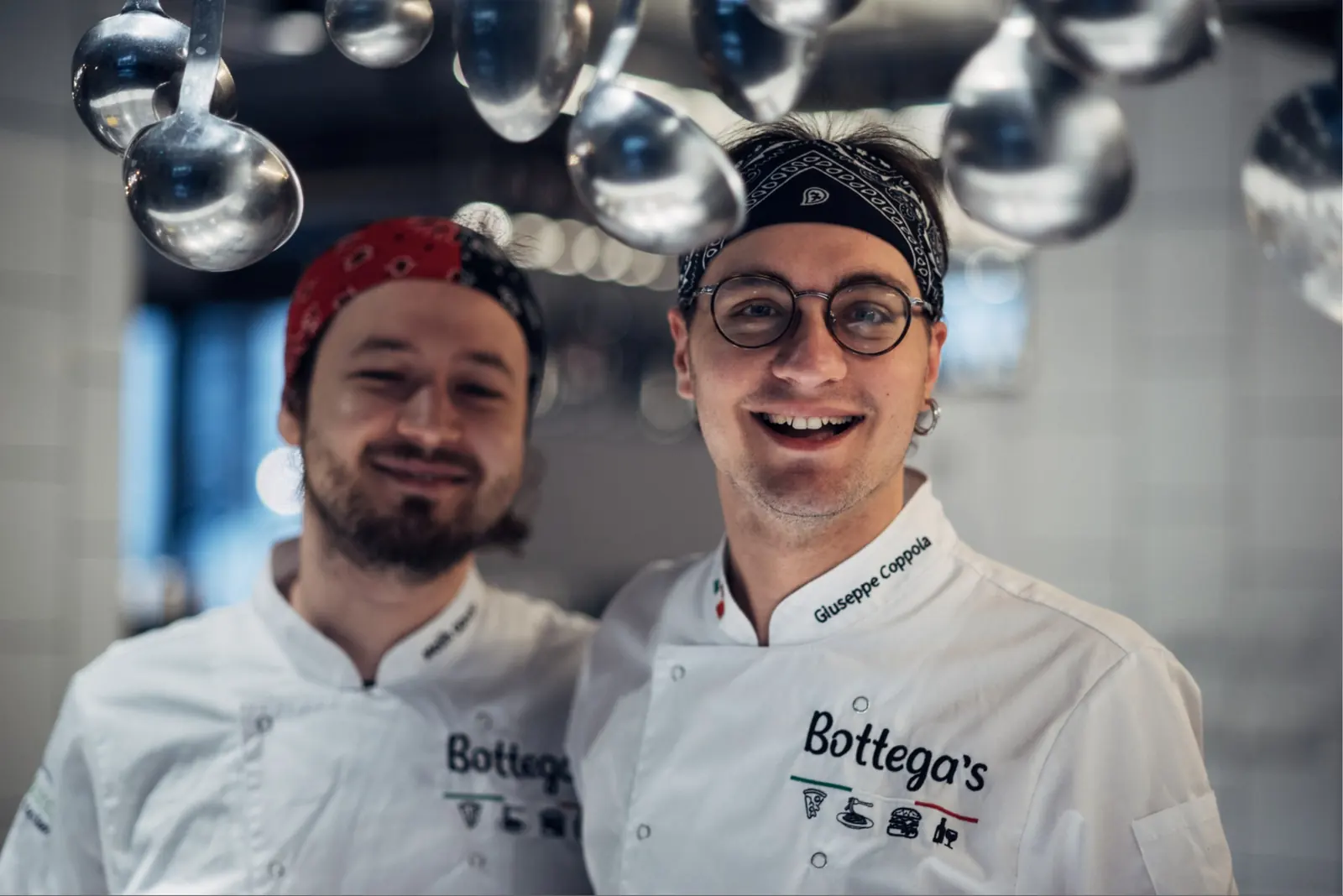 Pizzaioli Bottegas w kuchni, w kurtkach z logo Bottega's